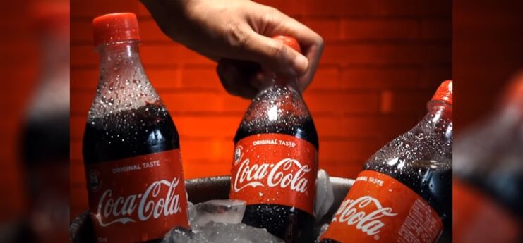 3 Bottles of Coca-Cola on a Bucket Full of Ice