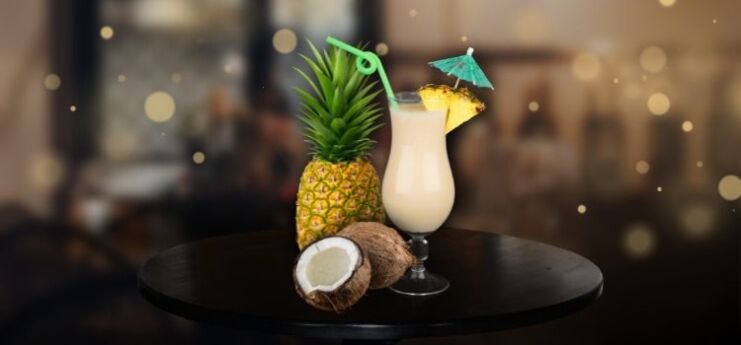 Pina Colada on desk with coconut and pineapple