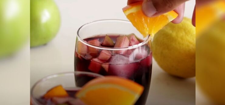 Putting Slice of Orange on a Glass of Sangria