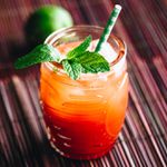 planter's punch cocktail with mint garnish and green-and-white-striped straw